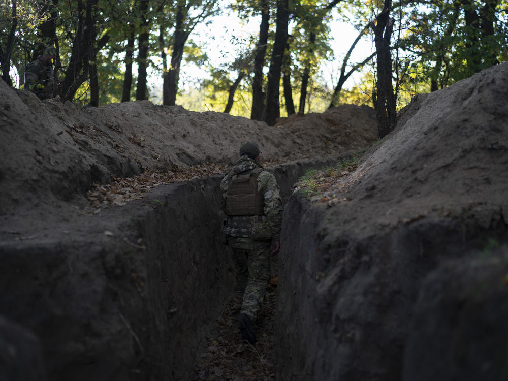 A Ukrainian serviceman checks the trenches dug by Russian soldiers in a retaken area in the Kherson region, Ukraine, on Oct. 12, 2022.