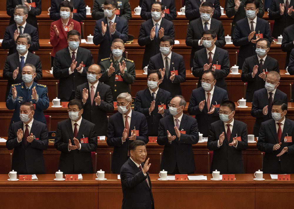 Chinese President Xi Jinping, right, is applauded as he waves to senior members of the government.