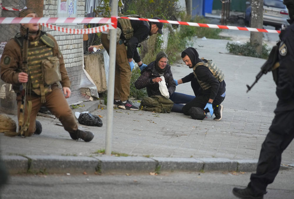 Medics help an injured woman after a drone fired on buildings in Kyiv on Monday.
