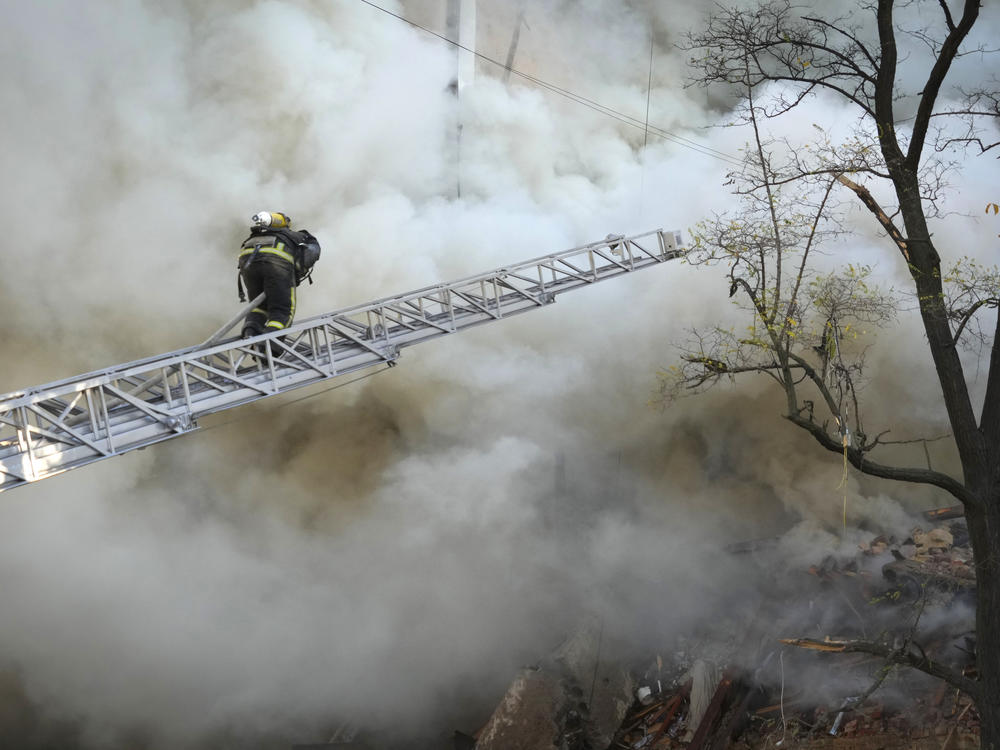 Firefighters work after a drone fired on buildings in Kyiv, Ukraine, Monday, Oct. 17, 2022.