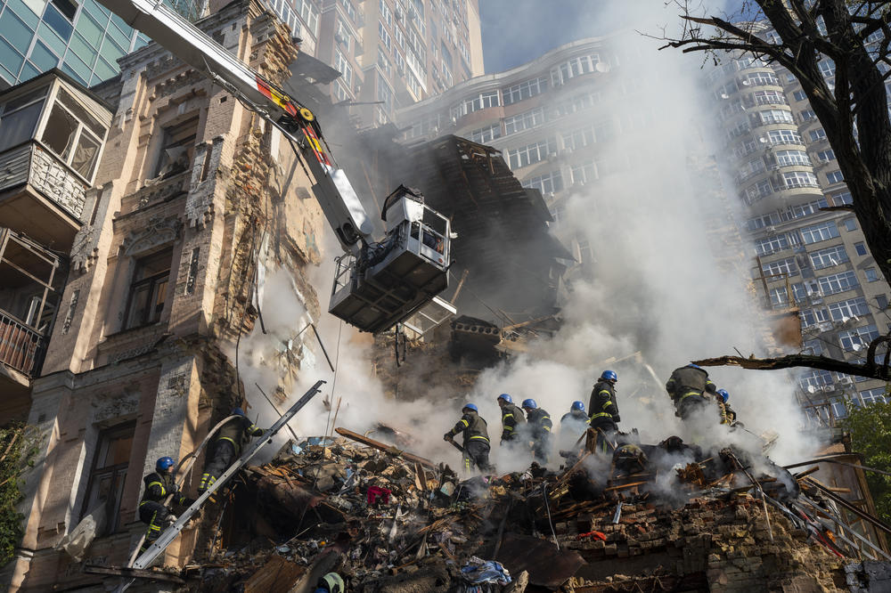 Firefighters work in the rubble of a building hit as part of a large-scale Russian attack on Kyiv.
