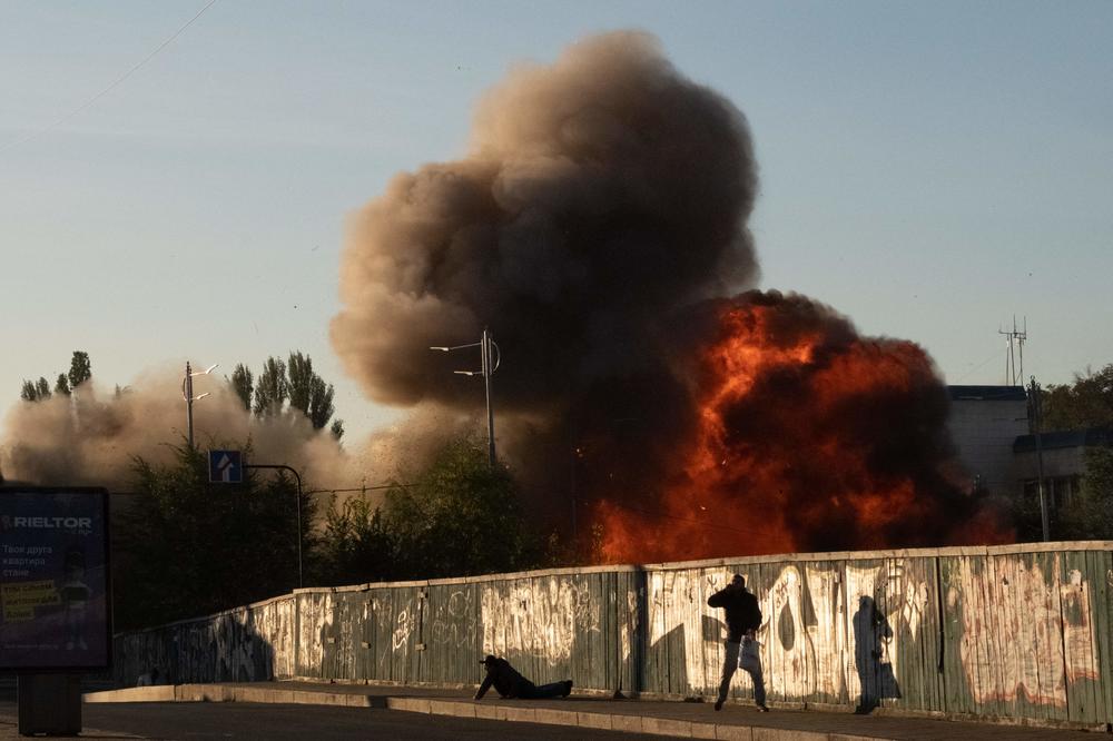 A man falls on the ground following a drone strike in Kyiv on Monday.