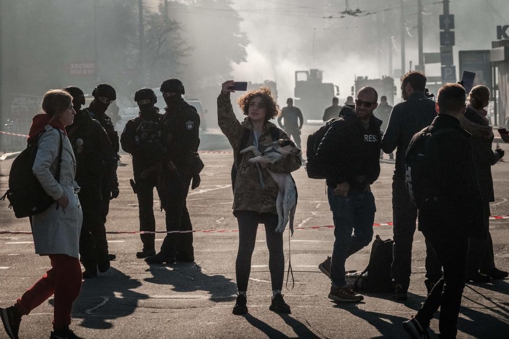 A local resident photographs a street after a drone attack in Kyiv on Monday.