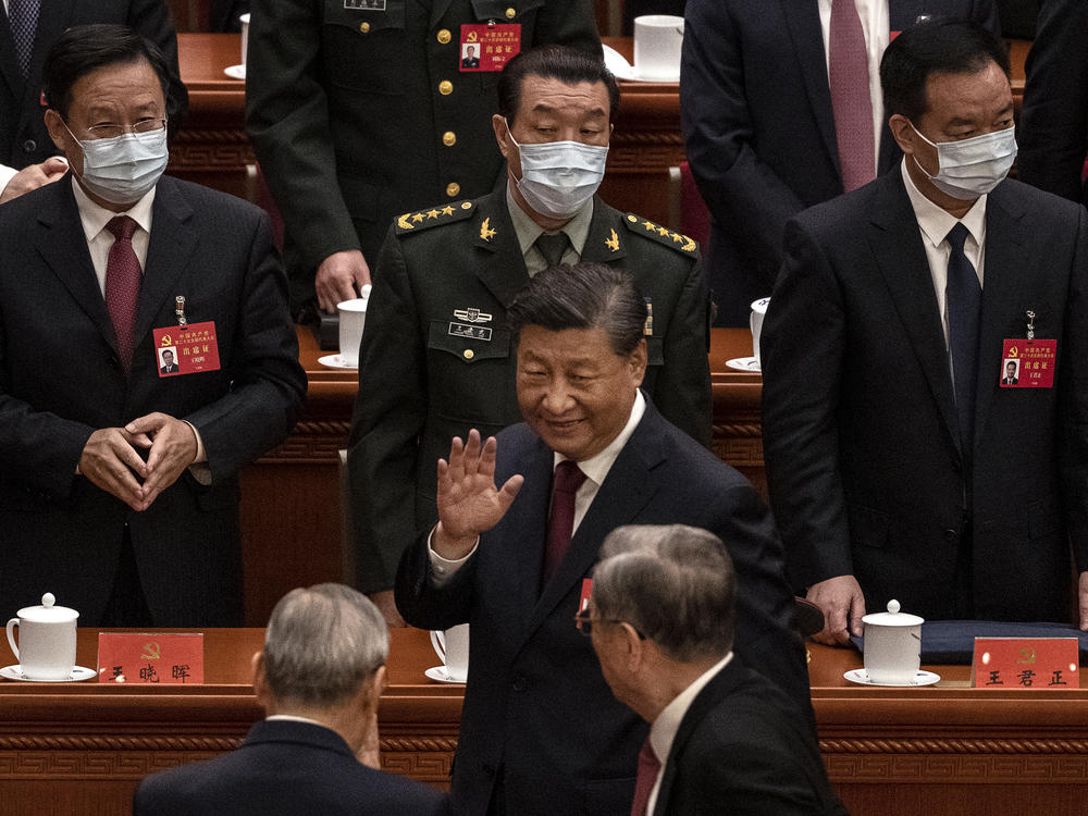 Chinese President Xi Jinping (center) waves to senior members of the government as he leaves at the end of the opening ceremony of the 20th National Congress of the Communist Party of China at The Great Hall of People in Beijing on Sunday.
