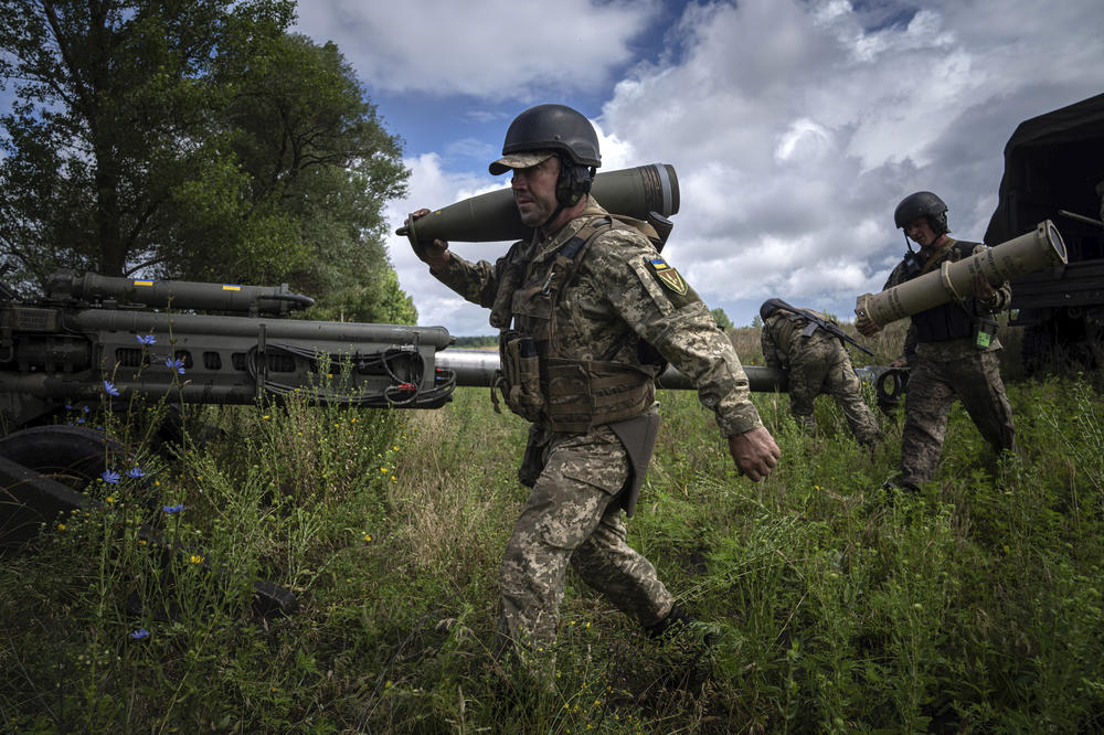 A Ukrainian serviceman carries a 155 mm artillery shell before firing at Russian positions from a U.S.-supplied M777 howitzer in the Kharkiv region, on July 14.