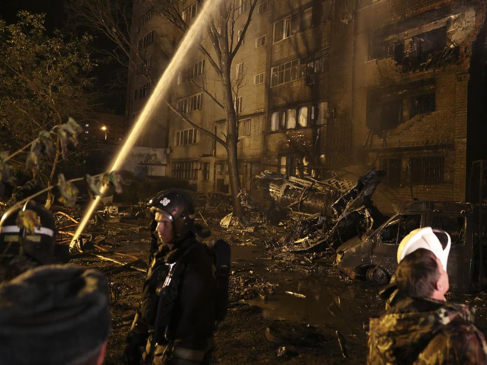 Firefighters work at the scene after a warplane crashed into a residential area in Yeysk, Russia, Monday, Oct. 17, 2022.