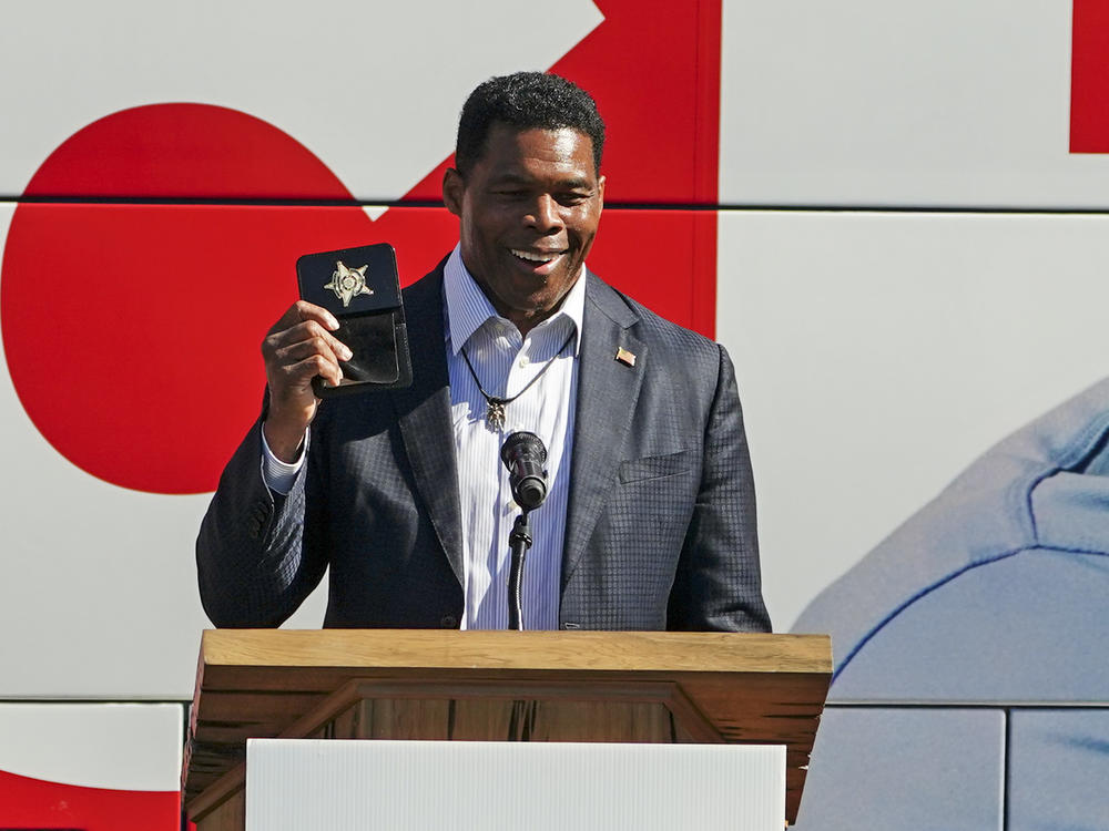 Republican candidate for U.S. Senate in Georgia Herschel Walker displays a law enforcement badge at a campaign rally Tuesday, Oct. 18, 2022, in Atlanta. Walker ordered 1,000 imitation badges to be dispersed at a fundraising event Thursday after his honorary badge drew controversy during a debate last week.