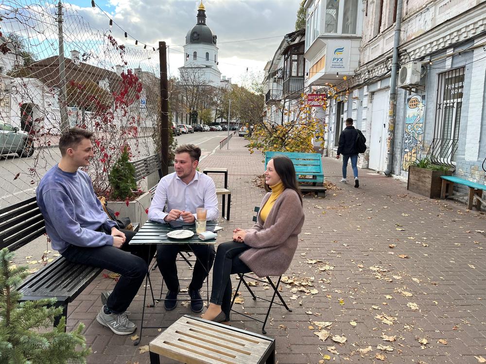 From left: Ivan Sushchyk, Vadym Zahozytsky and Yana Yelizarova discuss U.S. support for the war in Ukraine at a coffee shop in Kyiv on Oct. 11.