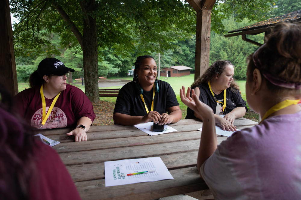 Andrea McAllister, Melissa Reeves and Becky Leach meet with fellow members of Camp Roundup's yellow cabin for the scavenger hunt on Sept. 3.