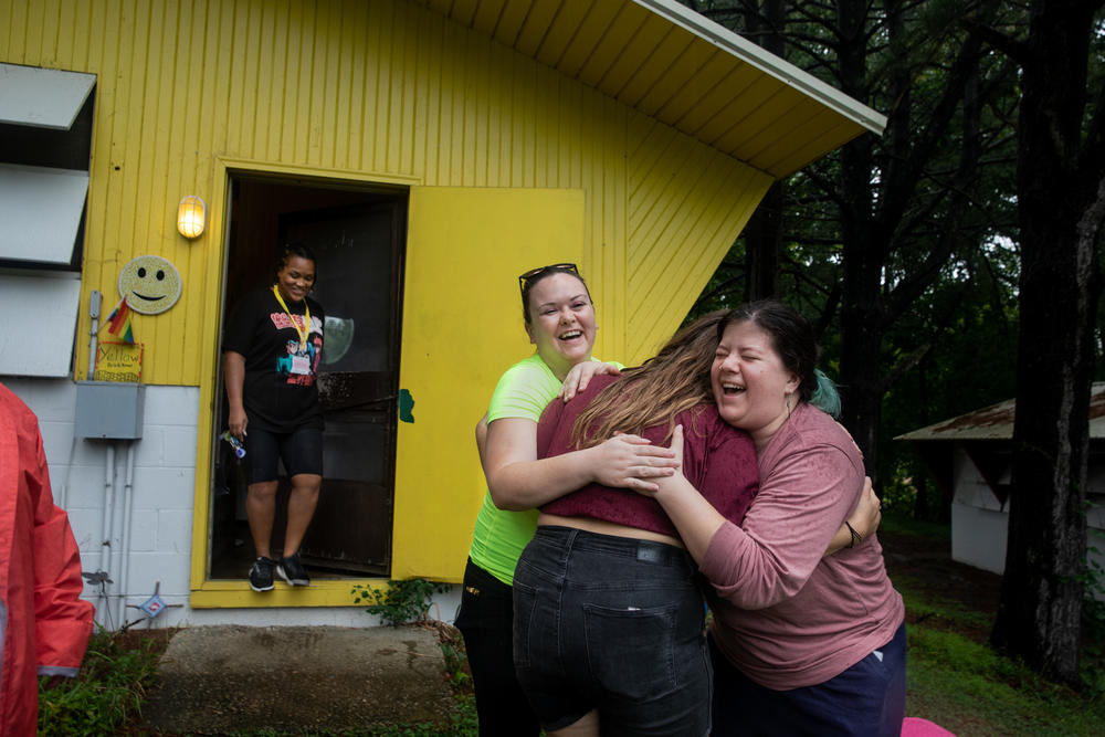 Mary Yale and Kylie Davis hug their counselor, Cat Ruehlman, before they leave Camp Roundup on Sept. 5 in Newark, Ohio.