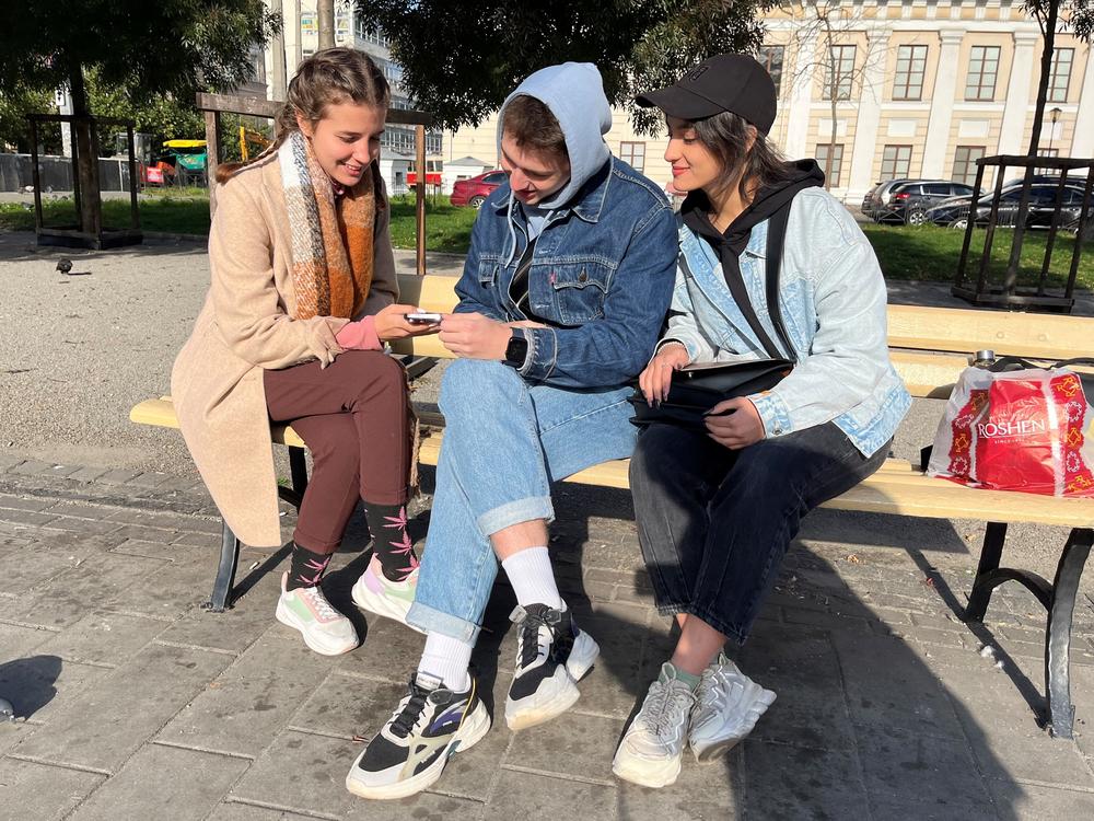 From left: Friends Marta Makarova, Kyrylo Bessarab, 20, and Chistyakova Valeriya, sit in Kontraktova Square in Kyiv on Oct. 11. They are worried about the possible loss of U.S. support for Ukraine if Republicans win the House in next month's midterm elections.