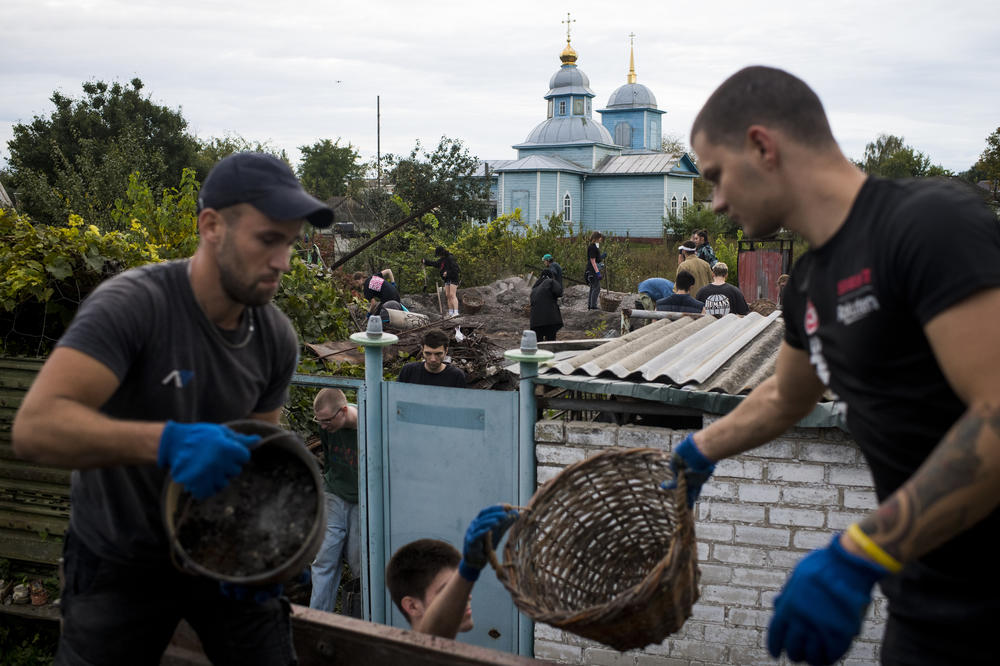 Repair Together volunteers work to clean up the destroyed home of Kateryna Yurchenko in Kolychivka.