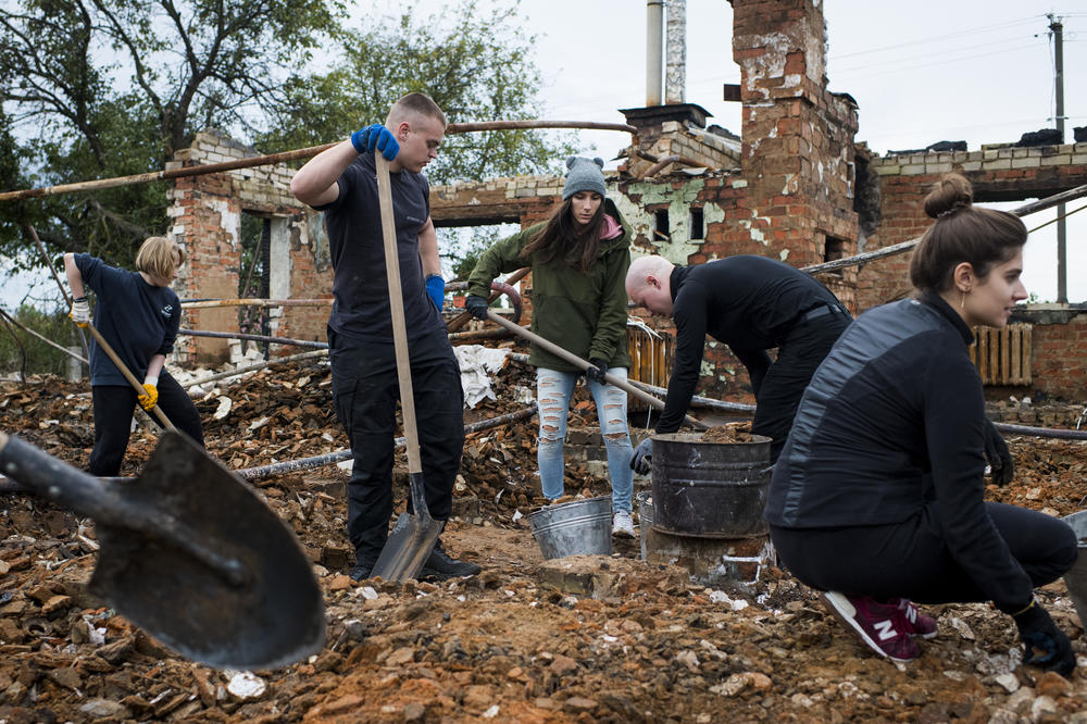 Repair Together volunteers work to clean up the home of Hanna Yurchenko in Kolychivka on Oct. 1.