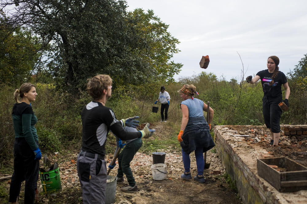 Volunteers from Repair Together work at the destroyed home of the Vereshchahina family in Kolychivka on Oct. 1.