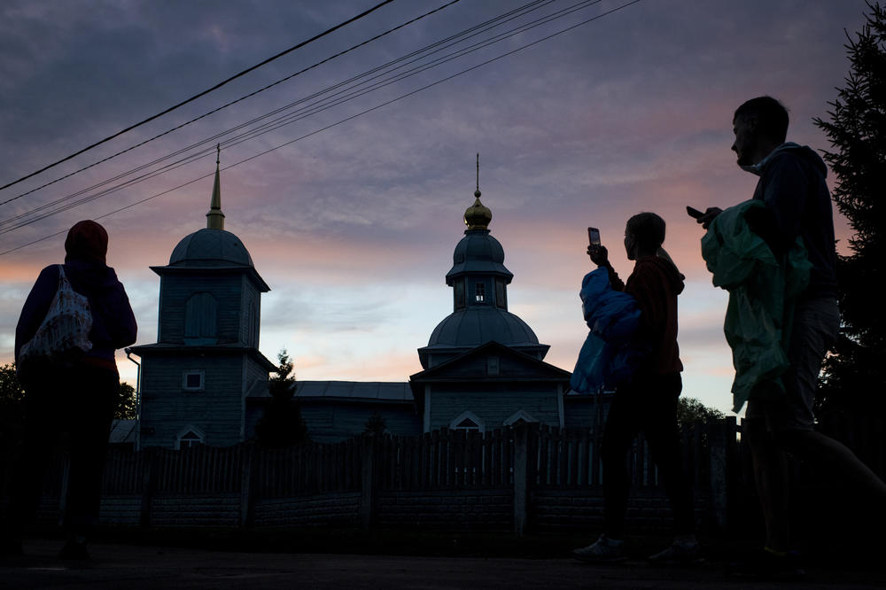 Repair Together volunteers photograph a church as the sun sets in Kolychivka on Oct. 1.