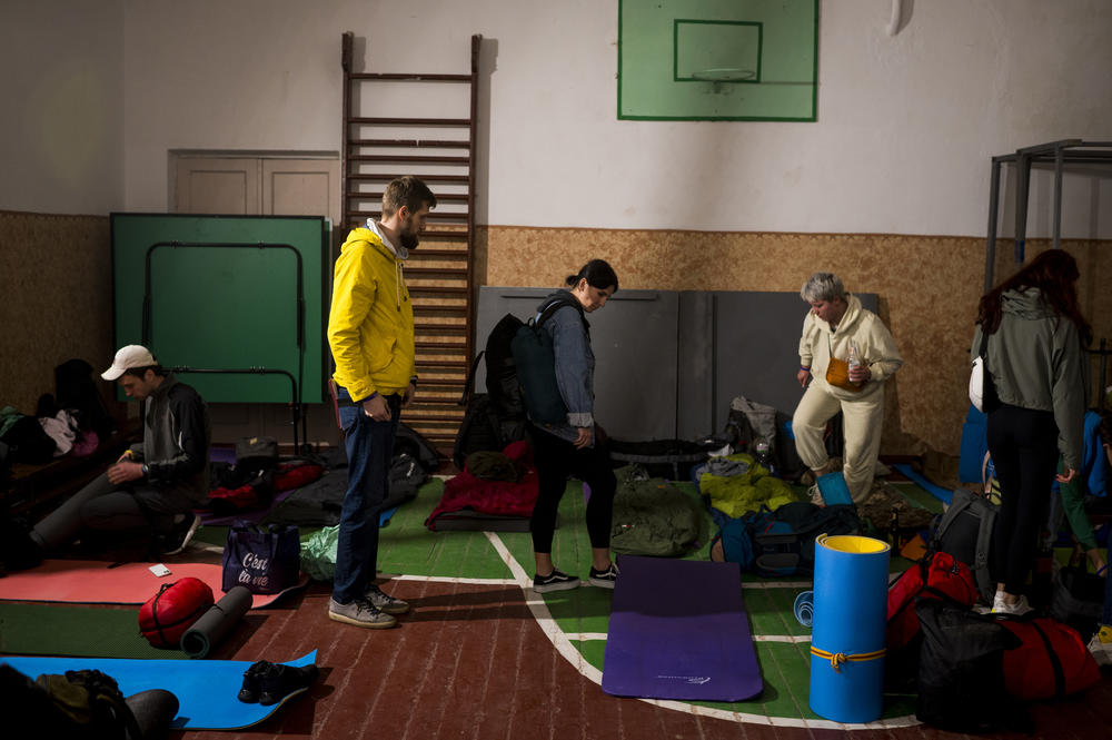 Volunteers put down sleeping pads in a school gym where they will sleep for the night in Anysiv, Ukraine, on Oct. 1.