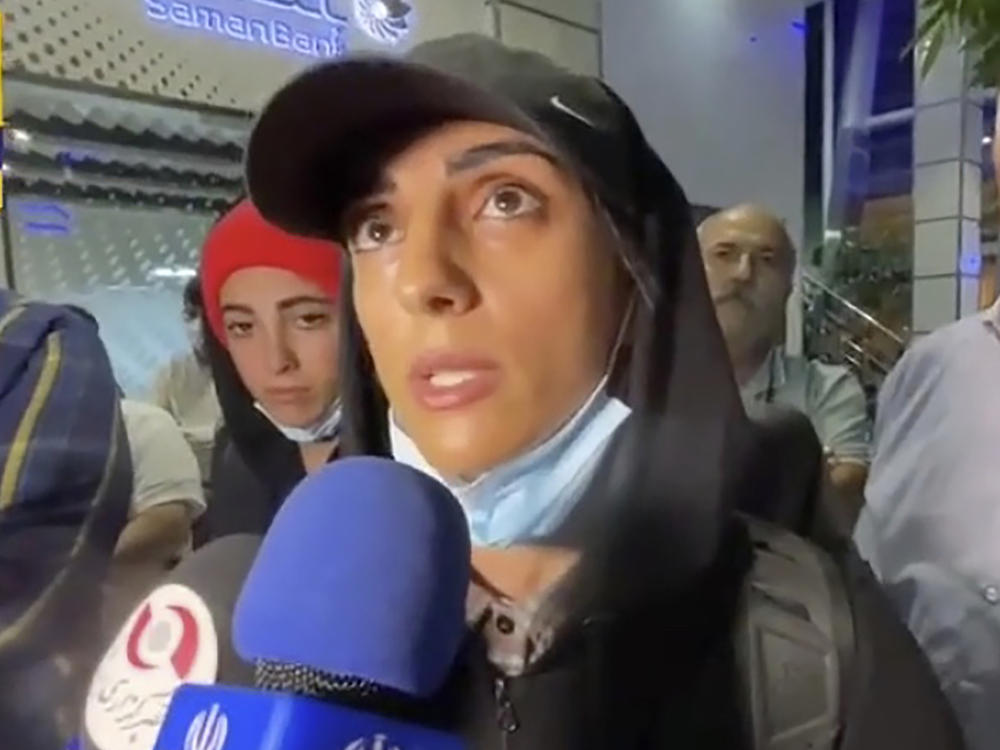 In this image taken from video by Iran's state-run IRNA news agency, Iranian competitive climber Elnaz Rekabi speaks to journalists in Imam Khomeini International Airport in Tehran, Iran, Wednesday, Oct. 19, 2022.