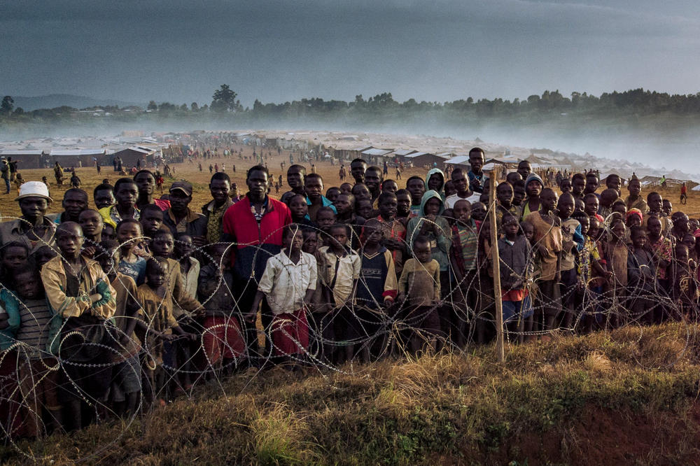 Dozens of displaced people gather along the fence of the United nations mission in the Democratic Republic of Congo.