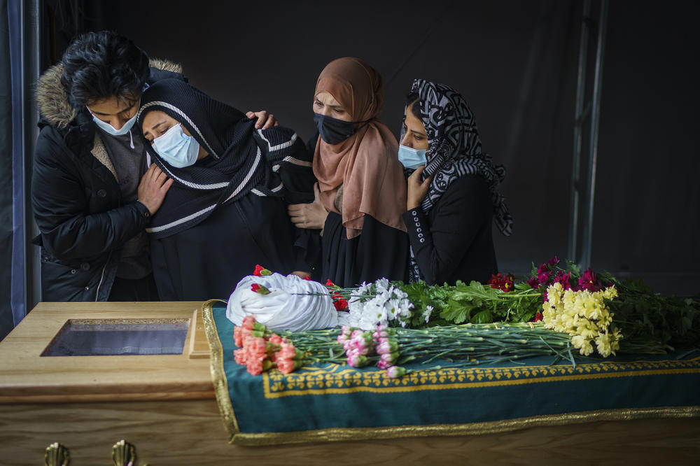 Family members pay their respects next to the body of a close relative, who died from COVID-19, during the coronavirus pandemic lockdown at Manchester Central Mosque in Manchester, U.K., on Feb. 24, 2021.
