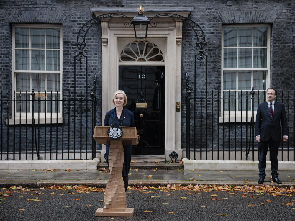 Prime Minister Liz Truss delivers her resignation speech as her husband, Hugh O'Leary, stands nearby at Downing Street in London on Thursday. Truss has been prime minister for just 44 days.