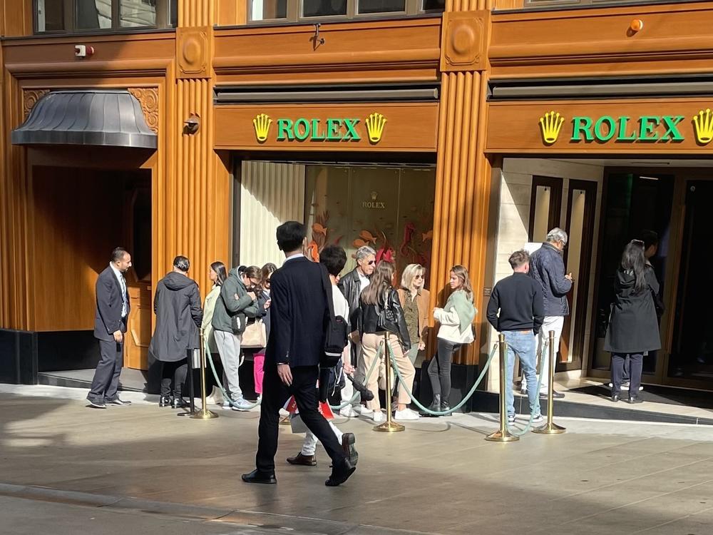 A line of people waits to enter a Rolex boutique in Geneva, Switzerland