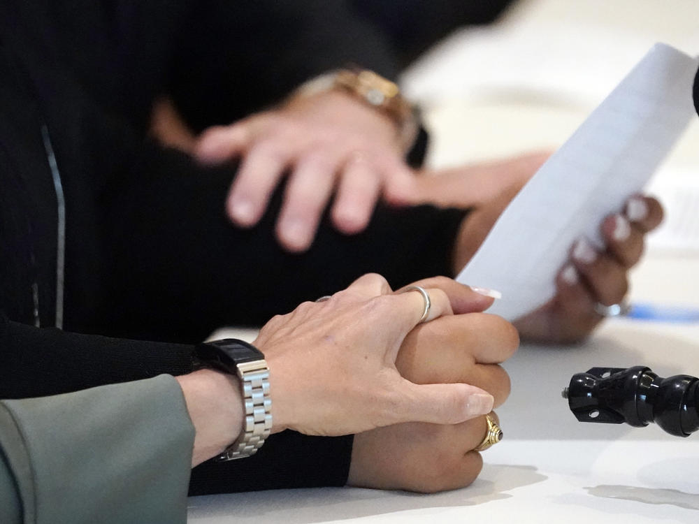 Two victims of UCLA gynecologist Dr. James Heaps hold hands during a May press conference (AP Photo/Marcio Jose Sanchez)