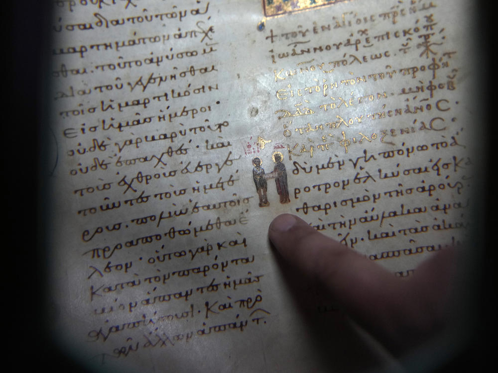 Father Theofilos, a Pantokrator monk, shows a manuscript at the library of Pantokrator Monastery in the Mount Athos, northern Greece, on Thursday, Oct. 13, 2022.