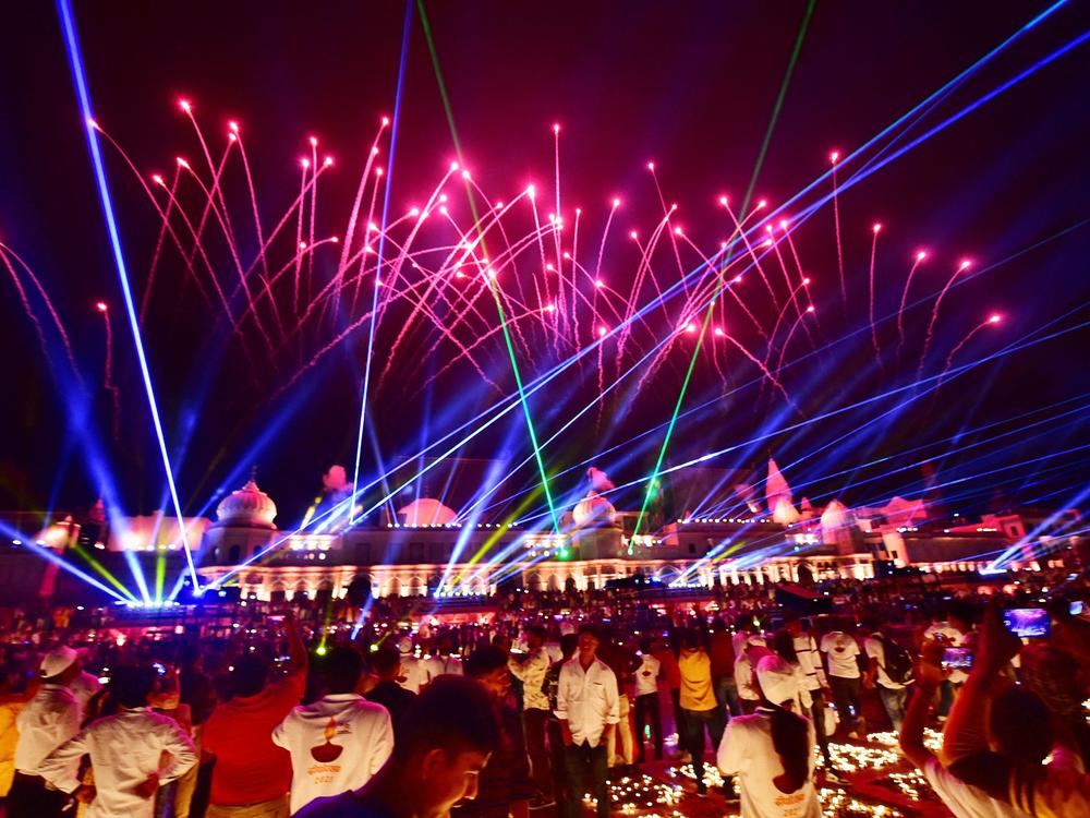 People watch a laser show on the banks of the river Sarayu during Deepotsav celebrations on the eve of the Hindu festival of Diwali in Ayodhya on November 3, 2021.