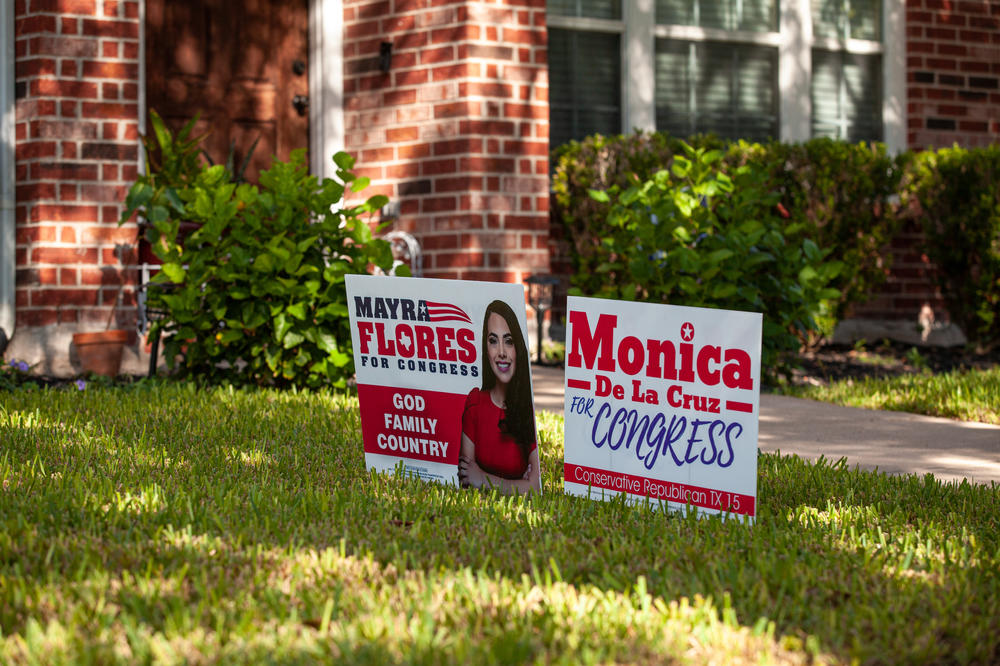 Signs for Monica De La Cruz and Mayra Flores in front of a home in Mission, Texas.