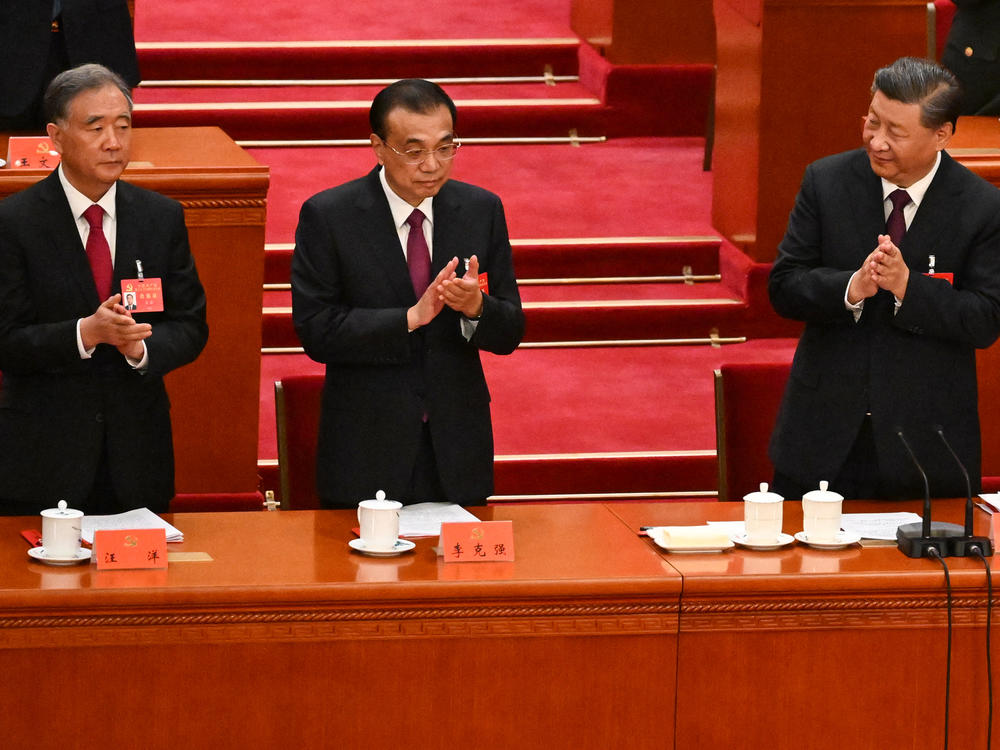 China's President Xi Jinping (right) applauds beside Premier Li Keqiang (center) and Politburo Standing Committee member Wang Yang during the closing ceremony of the 20th Chinese Communist Party's Congress in Beijing on Saturday.