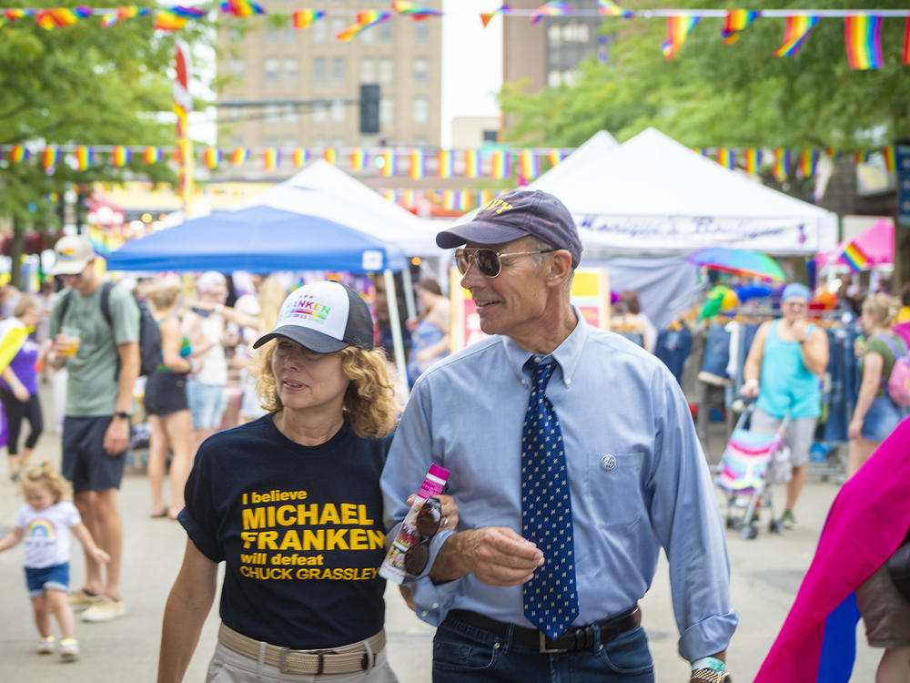 Retired Navy Adm. and Democratic U.S. Senate candidate Mike Franken walks with his wife along vendors at the Cedar Valley Pride Fest in Waterloo, Iowa, on Aug. 27.