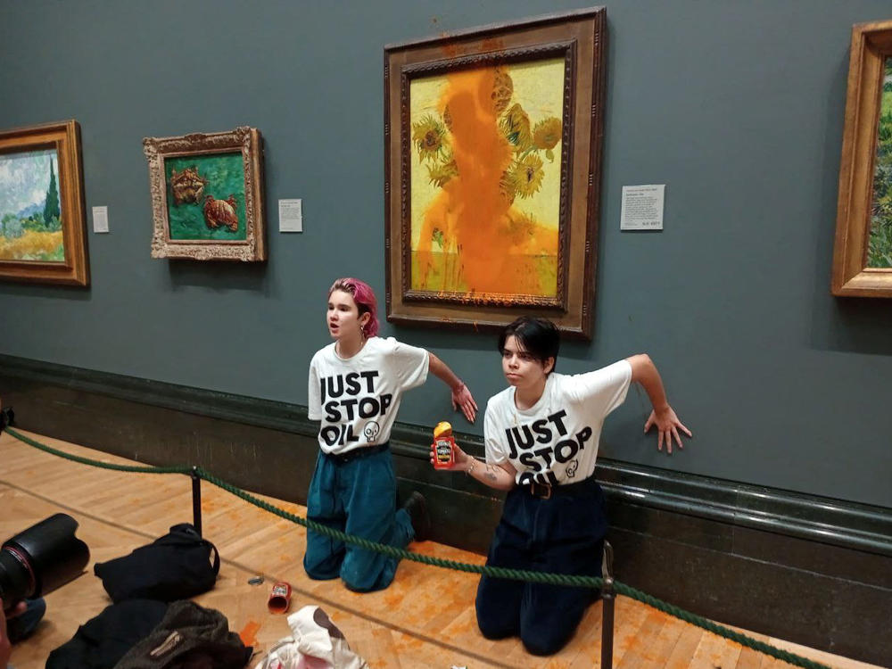 Just Stop Oil activists glue their hands to the wall after throwing soup at Vincent van Gogh's 