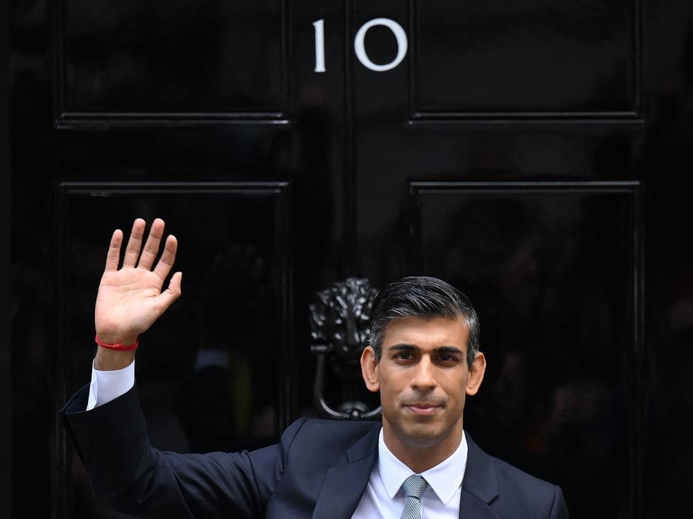 Rishi Sunak waves outside to door to No. 10 Downing Street on Tuesday after delivering his first speech as prime minister.