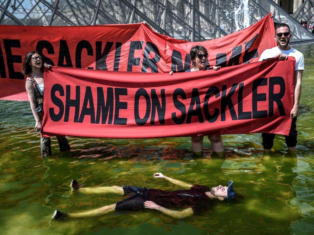 Activists hold banners reading 