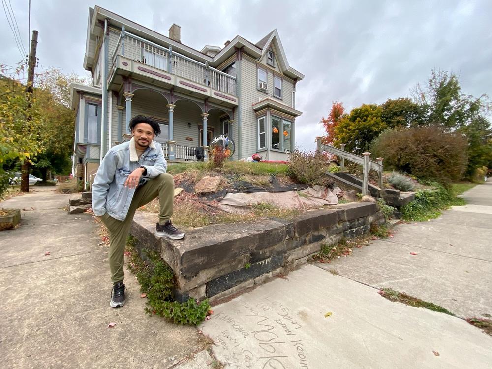 Beaver Falls native Cameron Mobley, pictured in front of his home, says he favors Democrat John Fetterman in Pennsylvania's competitive Senate race. The names of Mobley's children are etched into the sidewalk.