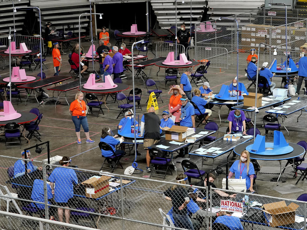 In this May 6, 2021, file photo, Maricopa County ballots cast in the 2020 general election are examined and recounted by contractors working for Florida-based company Cyber Ninjas at Veterans Memorial Coliseum in Phoenix.