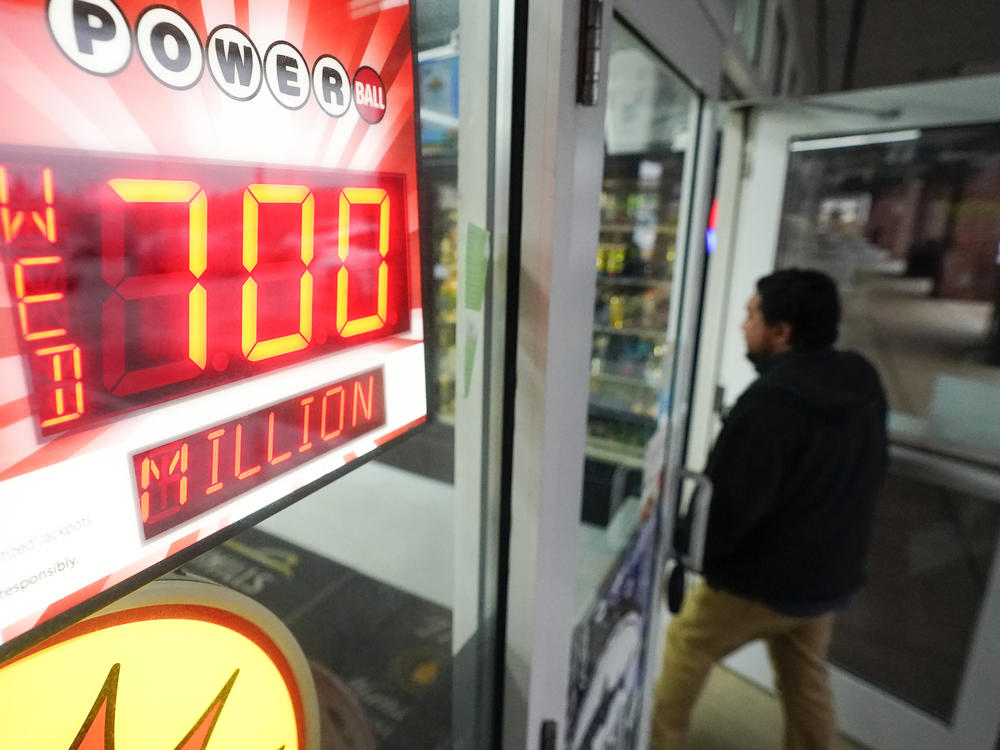 A patron enters a liquor store as a sign displays the Powerball jackpot, Tuesday, Oct. 25, 2022, in Baltimore.