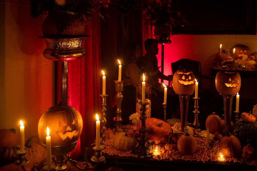 Jack-o'-lanterns and candles illuminate the front entrance.