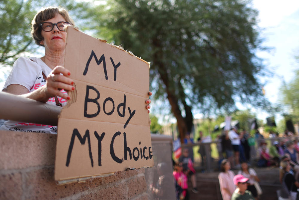 A protester holds a sign reading 'My Body My Choice' at a Women's March rally where Arizona Secretary of State and Democratic candidate for governor Katie Hobbs spoke outside the state Capitol on Oct. 8 in Phoenix.