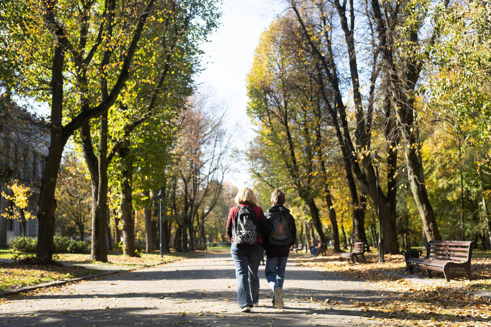 Hanna Korchevska and her son Ulysses walk through a park in Lviv. Sharing the single room among the four family members means they spend a lot of time out walking to avoid the cramped space.