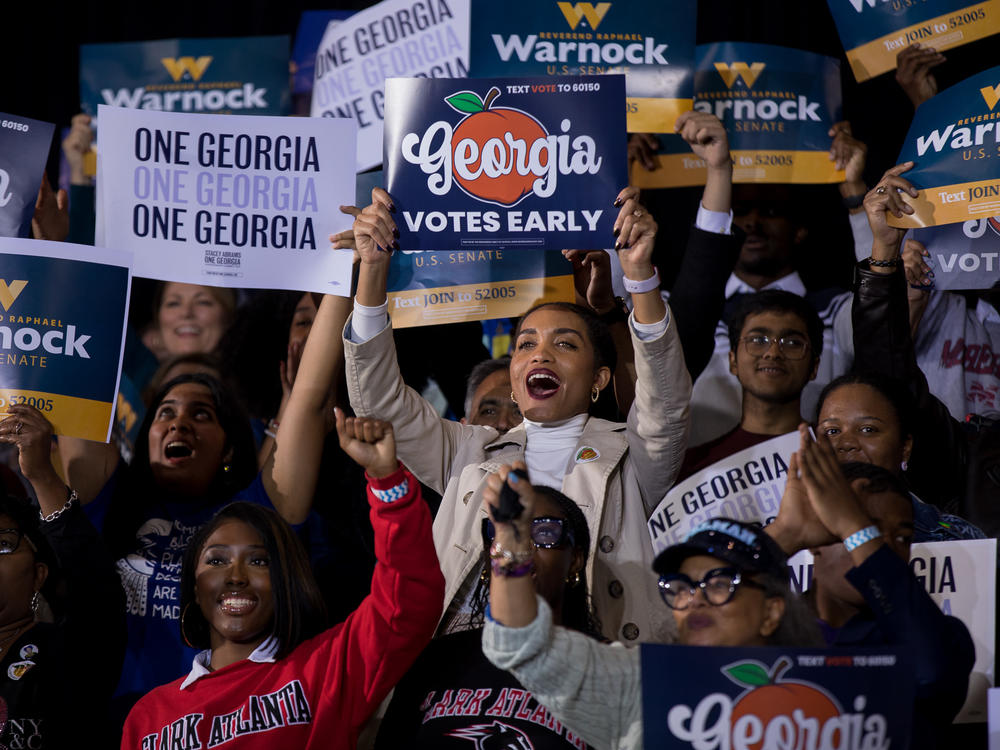 Supporters of Sen. Raphael Warnock and gubernatorial nominee Stacey Abrams cheer during a get out the vote rally in College Park, Ga. Warnock faces a tight reelection fight against Republican Herschel Walker.