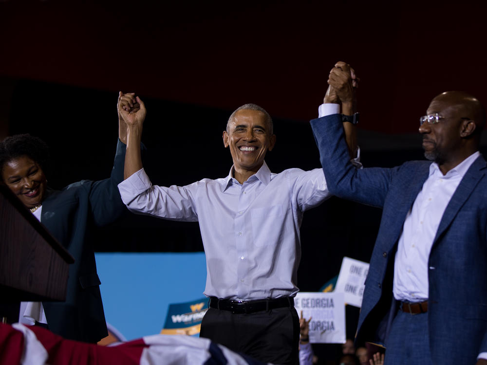 Georgia gubernatorial nominee Stacey Abrams, former President Barack Obama and Sen. Raphael Warnock cheer at a get out the vote rally in College Park, Ga., on Friday.