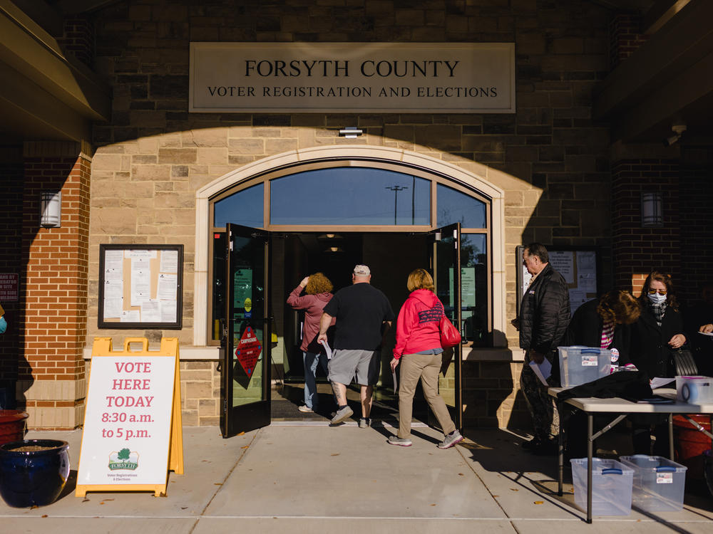 People walk into a polling location at the Elections and Voter Registration Office in Cumming, Ga.