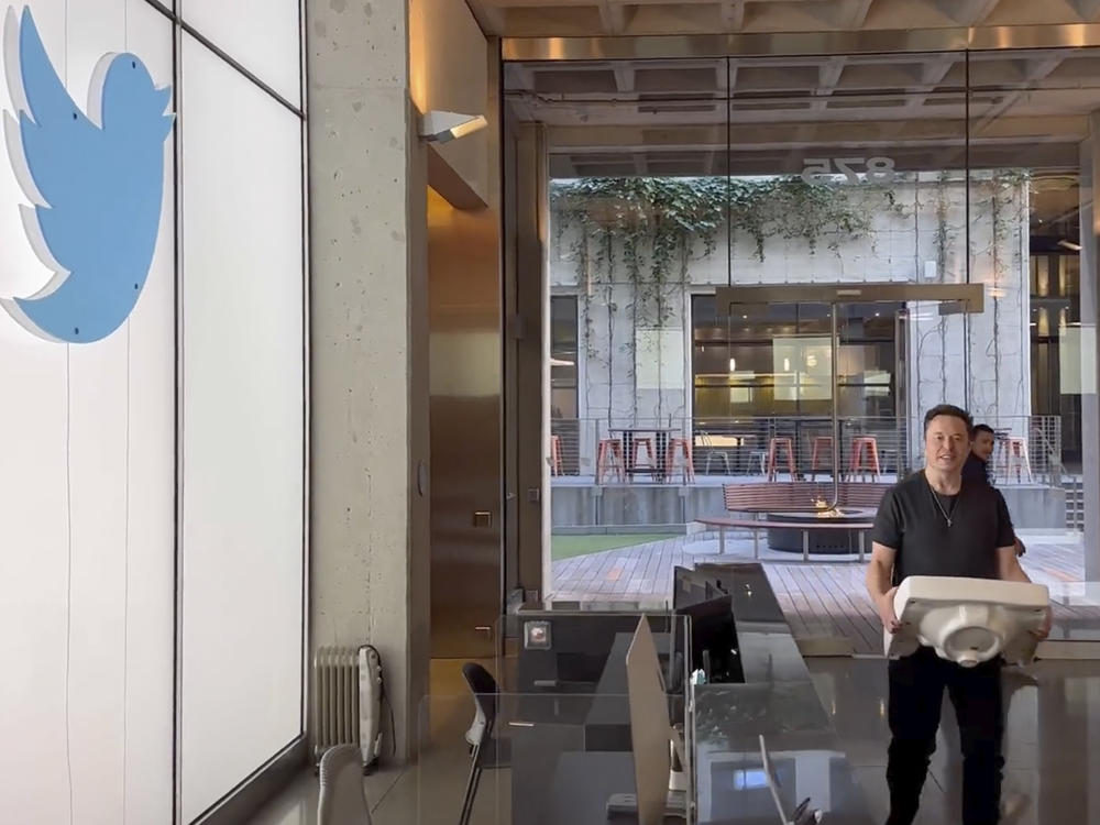 This image from the Twitter page of Elon Musk shows Musk entering Twitter headquarters carrying a sink through the lobby area on Wednesday, Oct. 26, 2022 in San Francisco. Musk posted a video Wednesday showing him strolling into Twitter headquarters ahead of a Friday deadline to close his $44 billion deal to buy the company.