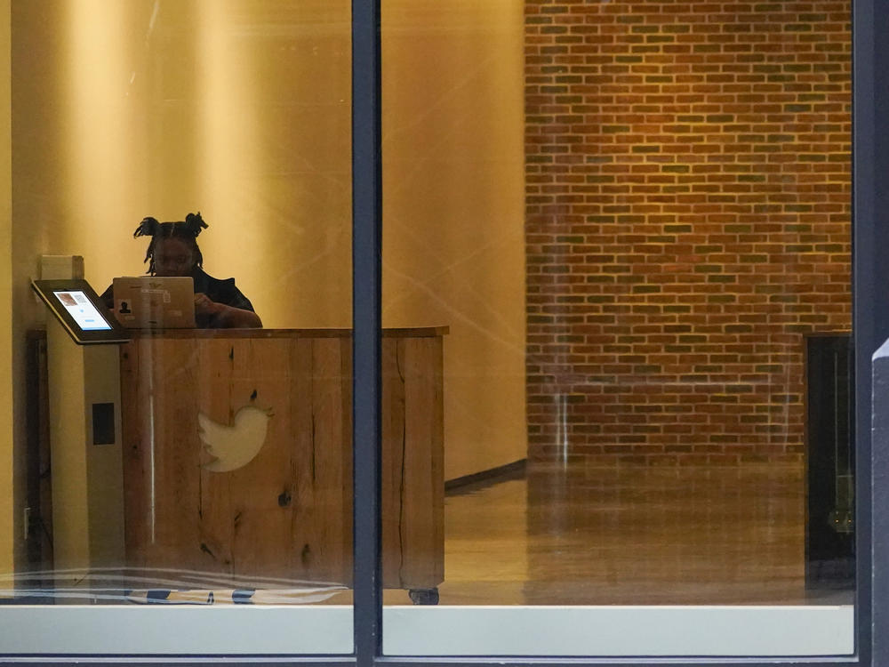 A receptionist works in the lobby of the building that houses the Twitter office in New York, Wednesday, Oct. 26, 2022.