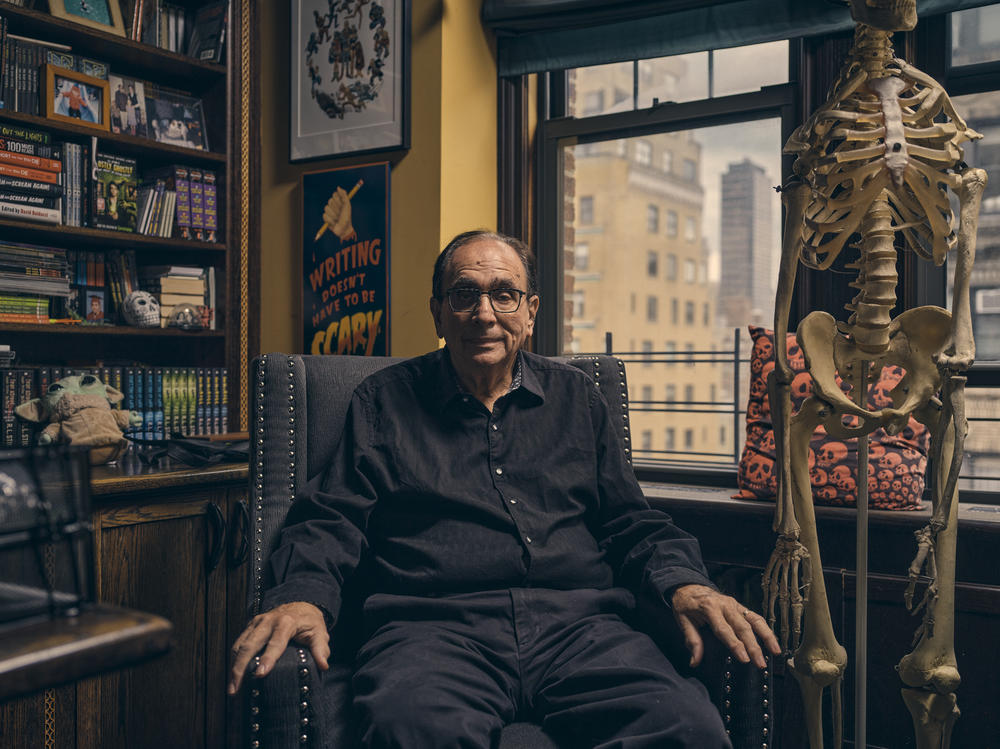 Horror author R.L. Stine sits next to a skeleton in his home in New York City. Stine's mega-popular kids book series <em>Goosebumps</em> turns 30 this year.