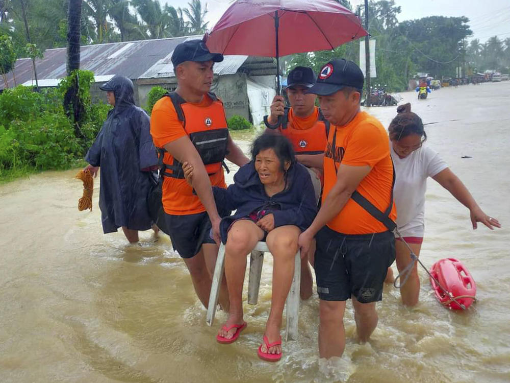 Rescuers evacuate residents from flood waters caused by Tropical Storm Nalgae in Hilongos, Leyte province, Philippines on Friday.