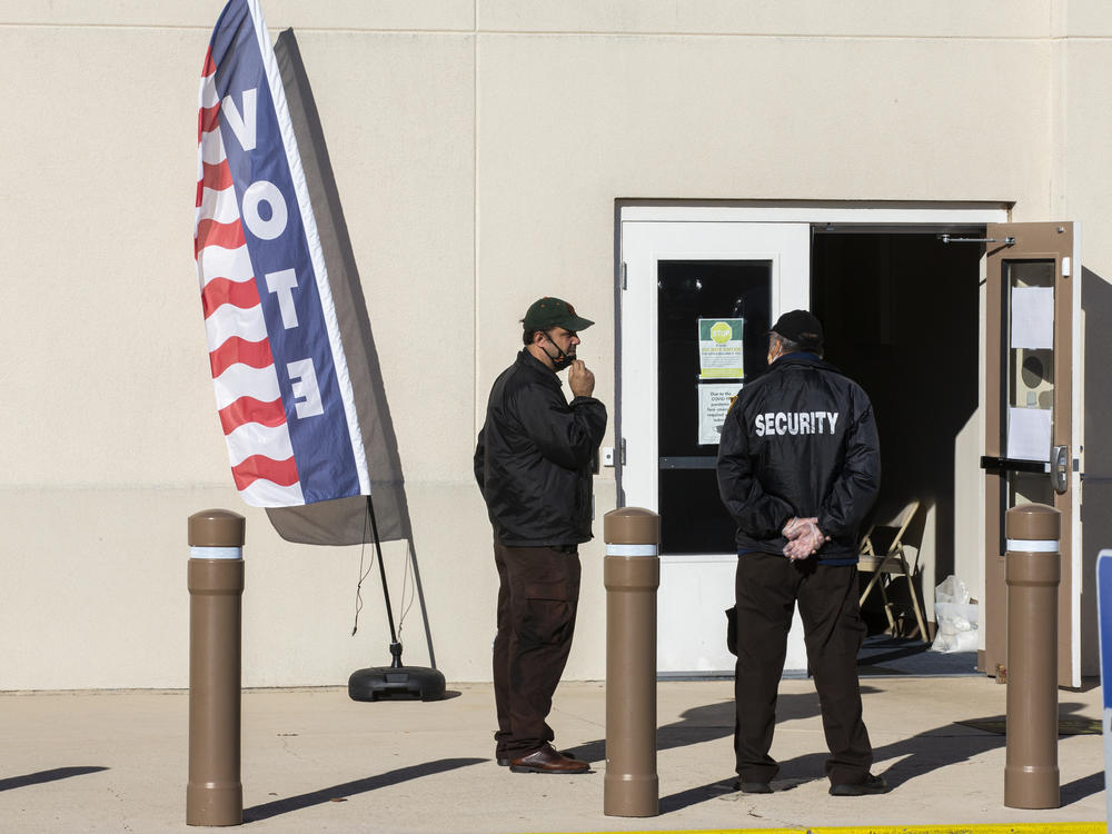 Security personnel wait for voters outside the Leon County Supervisor of Elections office on Nov. 3, 2020, in Tallahassee, Fla.