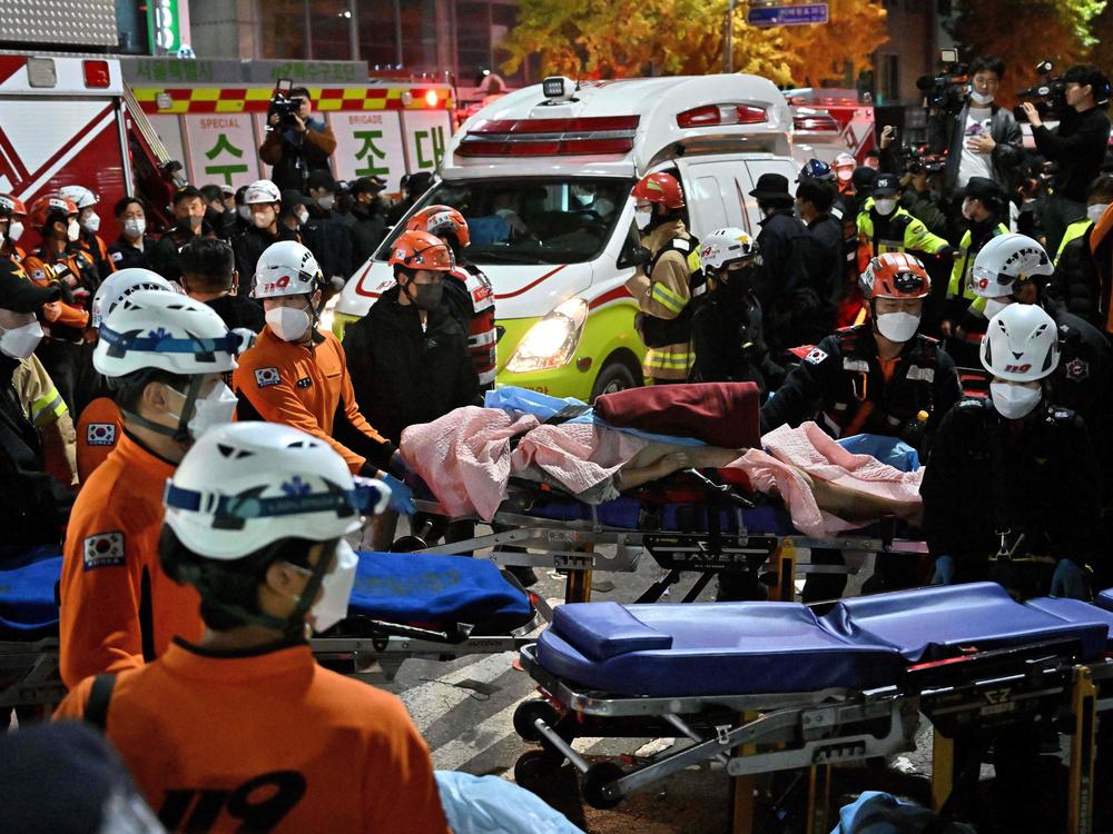 Medical staff transport a victim of a Halloween crush on a stretcher in the district of Itaewon in Seoul on October 30, 2022.