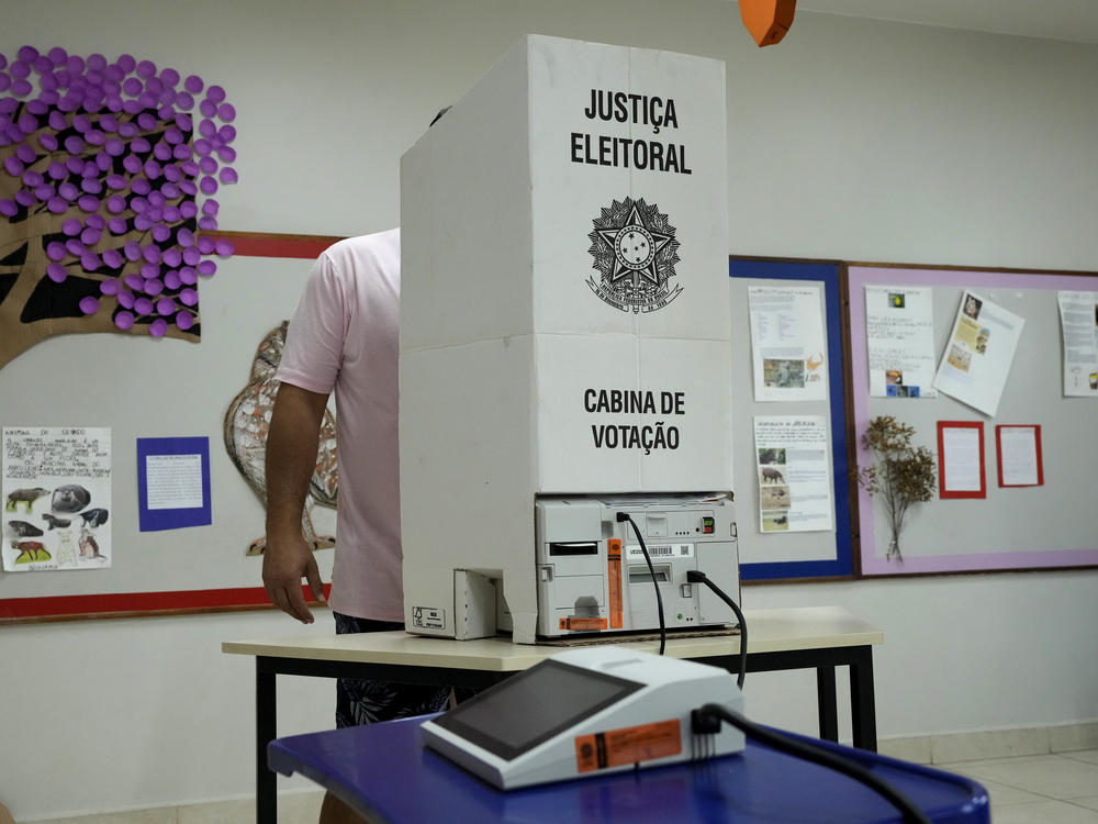 An electoral worker installs an electronic voting machine at a polling station in preparation for the presidential run-off election, in Brasilia, Brazil, Saturday, Oct. 29, 2022.